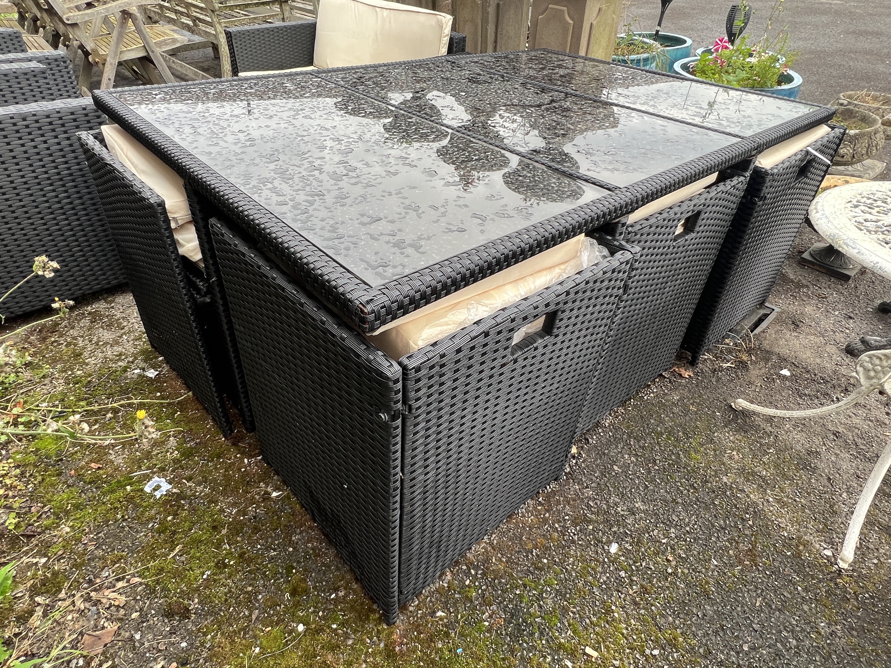 A black all weather rattan rectangular garden table and chair set, width 166cm, depth 109cm, height 67cm together with a matching three piece garden set with coffee table